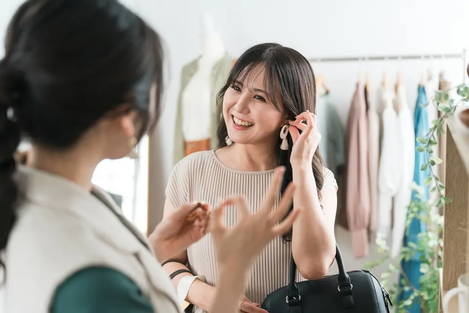 店員からアクセサリーの説明を受ける女性